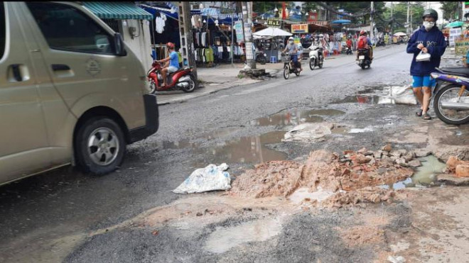 Hoặc dùng đất, đá, xỉ than tổ ong để trám ổ gà trên đường Tăng Nhơn Phú, đoạn qua phường Phước Long B. Ảnh: Quang Phương.