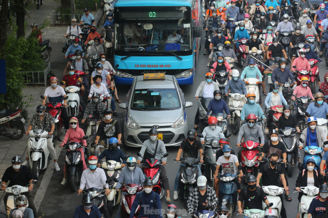 Taxi bị bủa vây bởi hàng chục xe máy nên không thể chuyển làn đành chấp nhận đi vào làn đường dành riêng cho xe máy.