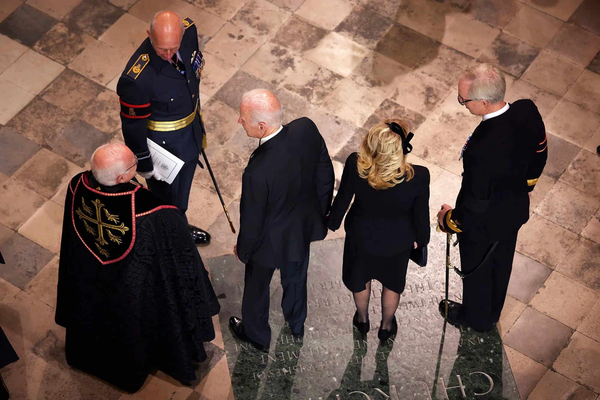 Ông Biden và phu nhân đứng chờ để được vào chỗ ngồi tại lễ viếng Nữ hoàng Anh. Ảnh: Getty