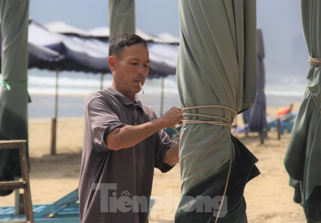 Ông Nguyễn Văn Sinh (Bãi dịch vụ kinh doanh số 3) cho hay, nhà ông có hơn 50 cây dù cùng hàng chục chiếc ghế phục vụ khách tắm biển. Nghe tin bão vào, sáng sớm nay ông cùng người nhà xuống thu dọn.