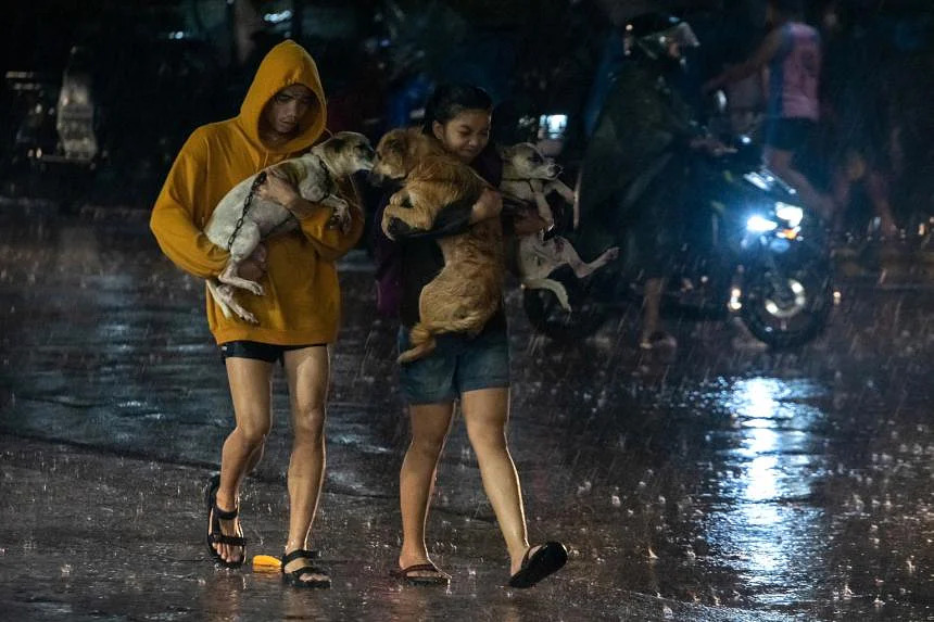 Người dân Manila mang chó đi sơ tán trong đêm ngày 25/9 (ảnh: Straitstimes)