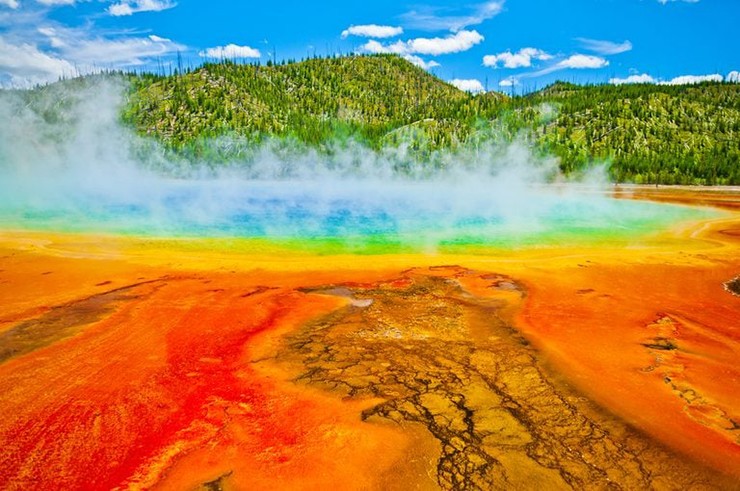 Grand Prismatic Spring ở Vườn quốc gia Yellowstone, Mỹ: Yellowstone có nhiều kỳ quan thiên nhiên, nhưng có lẽ rực rỡ và ăn ảnh nhất là hồ nước nóng nổi tiếng&nbsp;Grand Prismatic Spring. Đúng như tên gọi, suối nước nóng có kích thước bằng sân bóng đá này được bao quanh bằng các vòng màu vàng, xanh lục và cam do vi khuẩn ưa nhiệt tiết ra. Ở trung tâm là một dải nước trong xanh rực rỡ.
