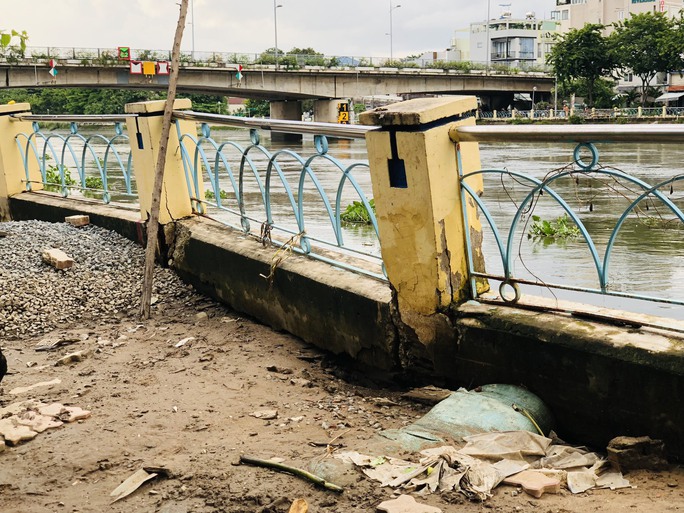 Tường rào khu vực sạt lở hồi cuối tháng 6-2023 đang nghiêng lún, có nguy cơ đổ xuống sông bất cứ lúc nào (Ảnh ÁI My)