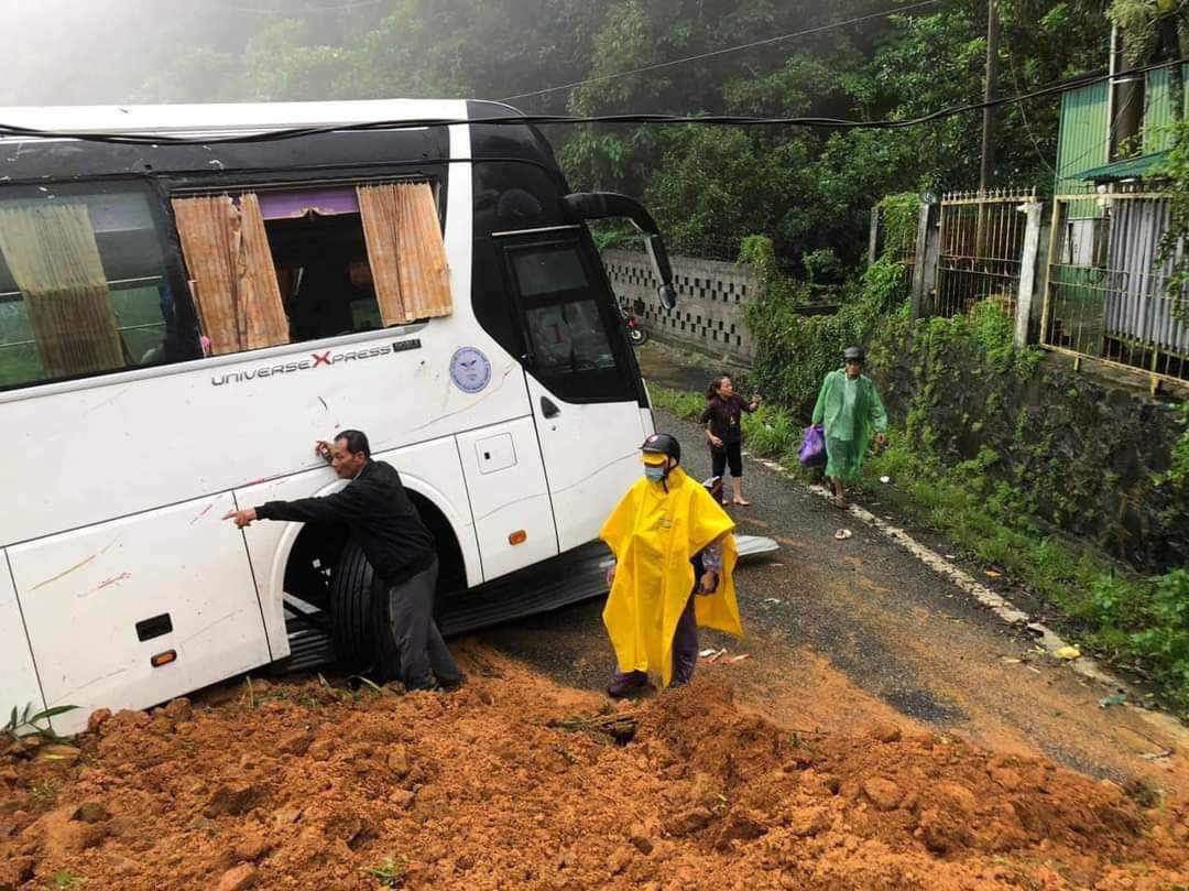 Xe khách chạy ngang bị khối đất đá đè trúng, ép sát vào lan can bảo vệ