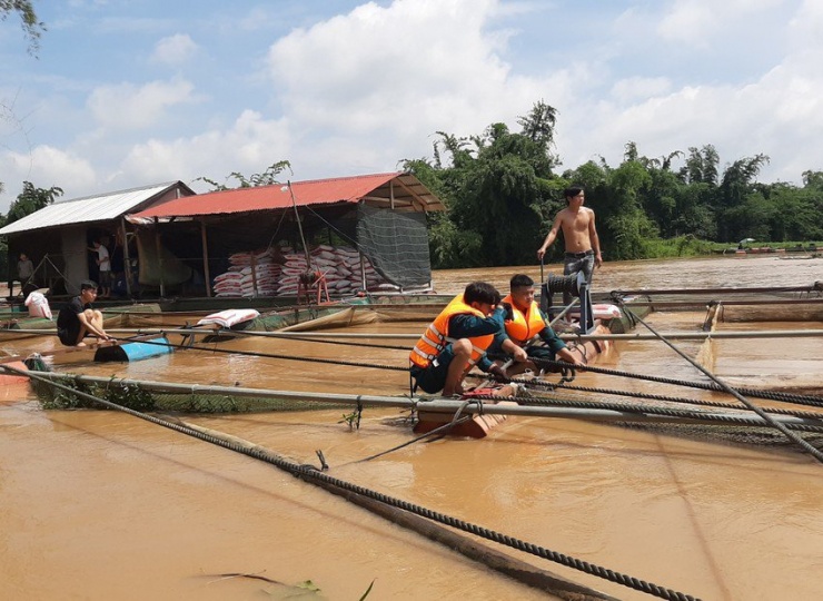 Nước lũ dâng cao khiến người nuôi cá bè lo lắng. Ảnh: VH.