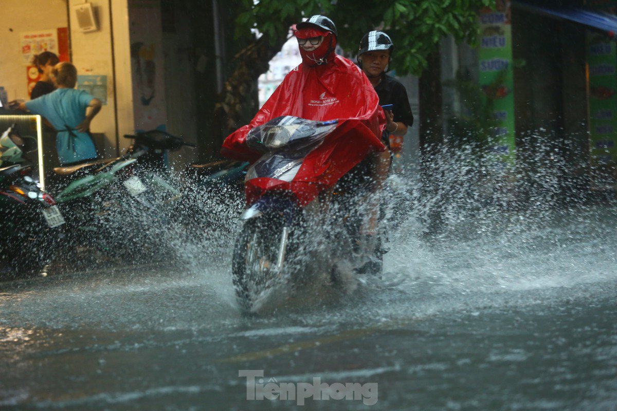 Mưa tầm tã, người dân Hà Nội chật vật &#34;bơi qua biển nước&#34; - 20