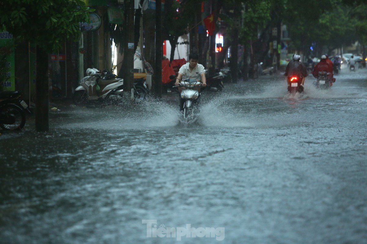 Mưa tầm tã, người dân Hà Nội chật vật &#34;bơi qua biển nước&#34; - 23