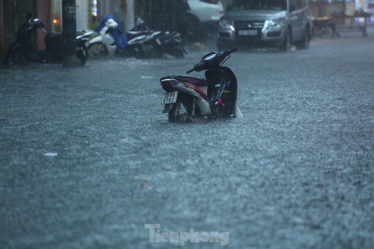 Mưa tầm tã, người dân Hà Nội chật vật &#34;bơi qua biển nước&#34; - 9