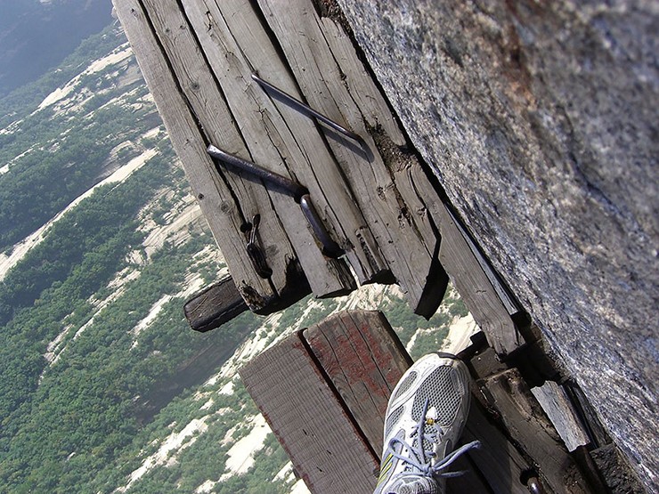 Tiếp theo là trò chơi “Vast Sky Plank Walk” rất nổi tiếng dọc theo vách đá của đỉnh Nam Hoa Sơn. Đó là một trải nghiệm đứng trên bục gỗ rộng 61cm gắn vào mặt vách đá ở độ cao 2.160m so với mực nước biển. Đừng nhìn xuống nếu bạn sợ độ cao.
