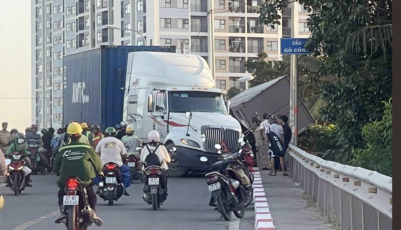 Xe tải nằm đè lên thành cầu sau va chạm với xe container