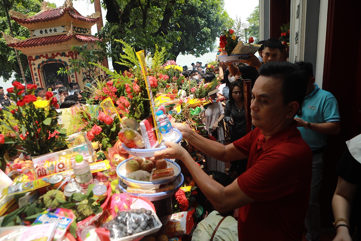 Thậm chí, có những người phải đưa mâm lễ lên cao để di chuyển dễ dàng hơn. Không những vậy, vị trí bày đồ lễ trên ban không còn, nhiều người phải đội mâm lễ lên đầu và vái vọng từ xa.