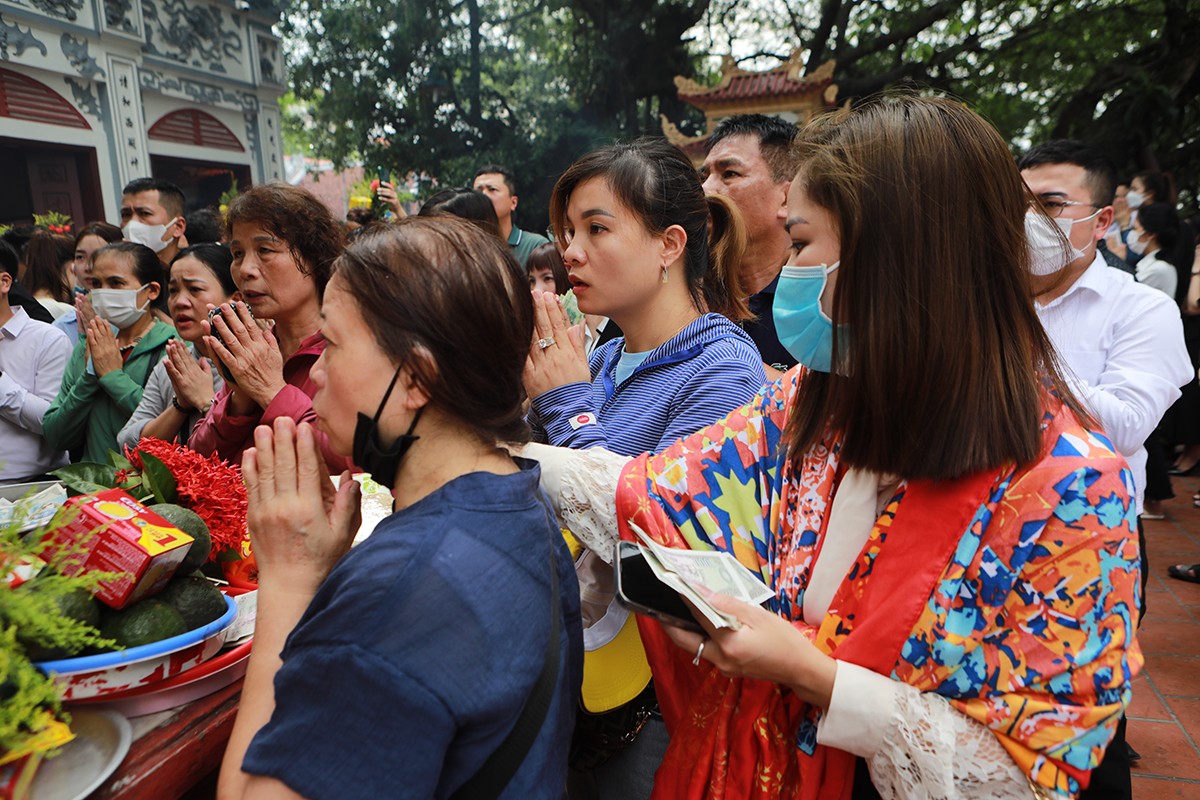 Những người không đi được vào bên trong đành đứng giữa sân làm lễ, khấn vái cầu bình an dưới trời nắng nóng.