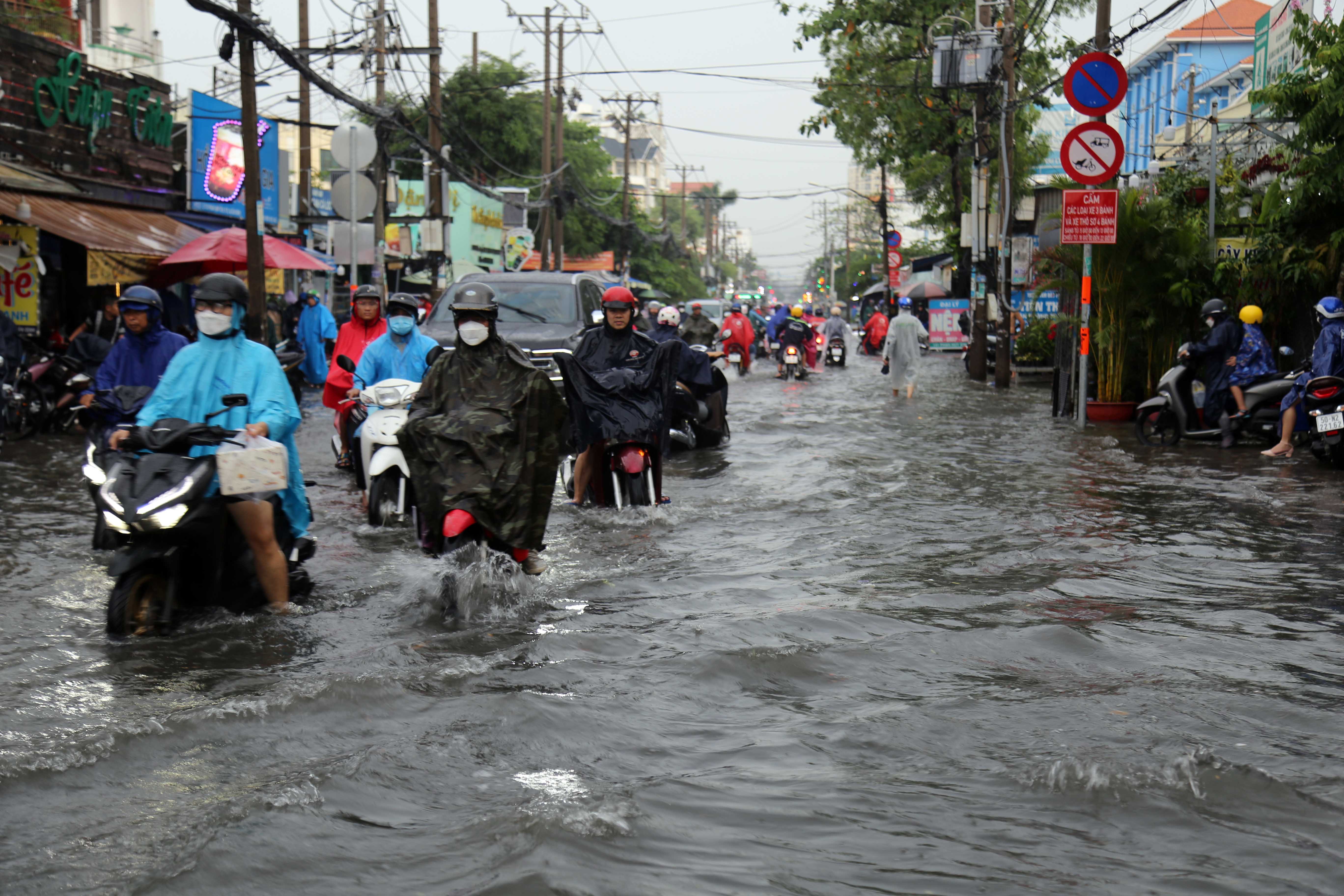 Nước lênh láng trên đường sau mưa. Việc di chuyển của người dân rất khó khăn do nước ngập kéo dài.