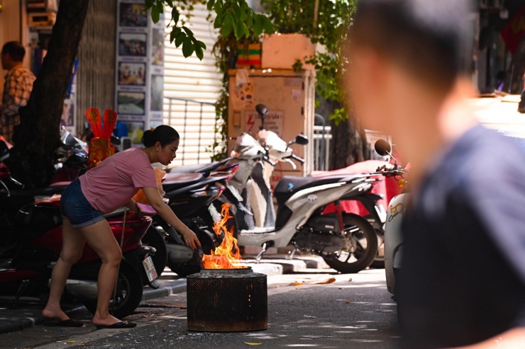 Hình ảnh tại phố Nguyễn Siêu (quận Hoàn Kiếm), do xe máy để tràn vỉa hè, một phụ nữ mang lò xuống lề đường để hóa vàng.