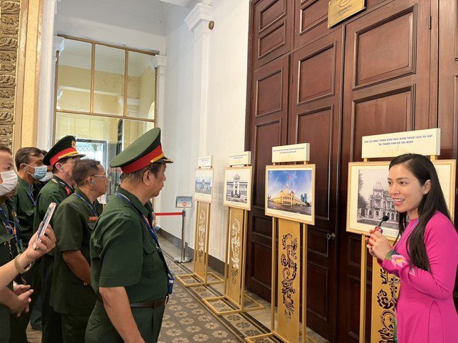 Các cựu chiến binh đang nghe Hướng dẫn viên giới thiệu về quá trình hình thành trụ sở HĐND - UBND TPHCM