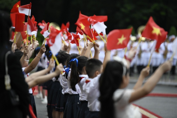 Các em thiếu nhi Hà Nội vẫy quốc kỳ hai nước chào đón Thủ tướng Singapore Lý Hiển Long. (Ảnh: Như Ý)