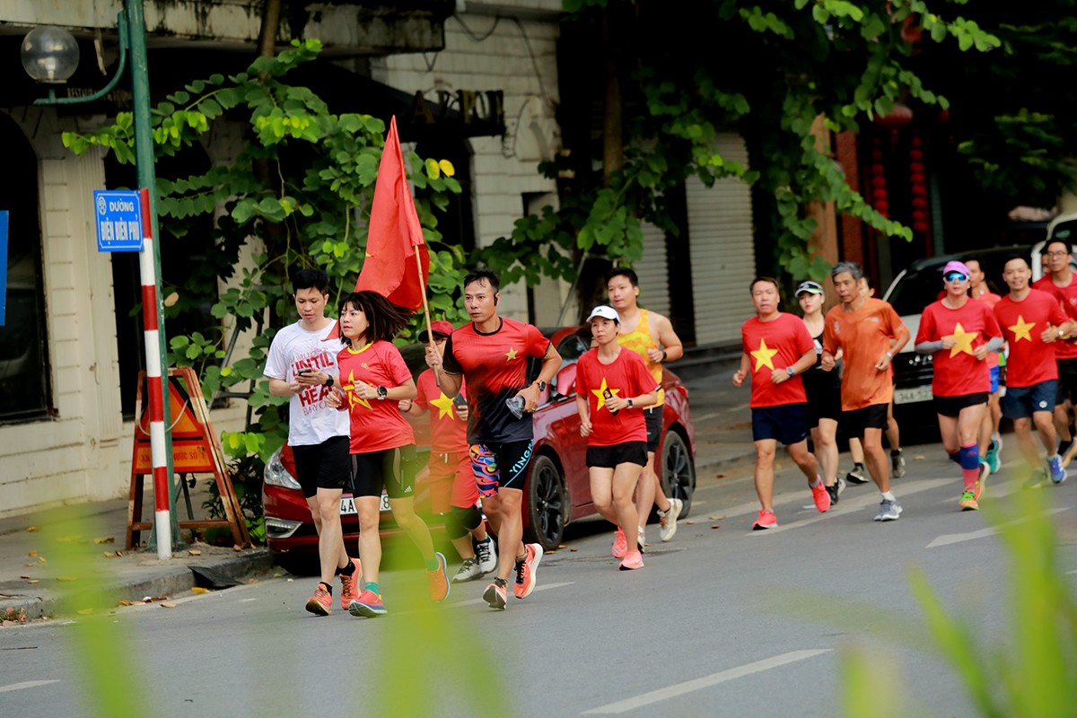 Đường Điện Biên Phủ (quận Ba Đình) rất đông người mặc áo cờ Tổ quốc chạy trên phố.