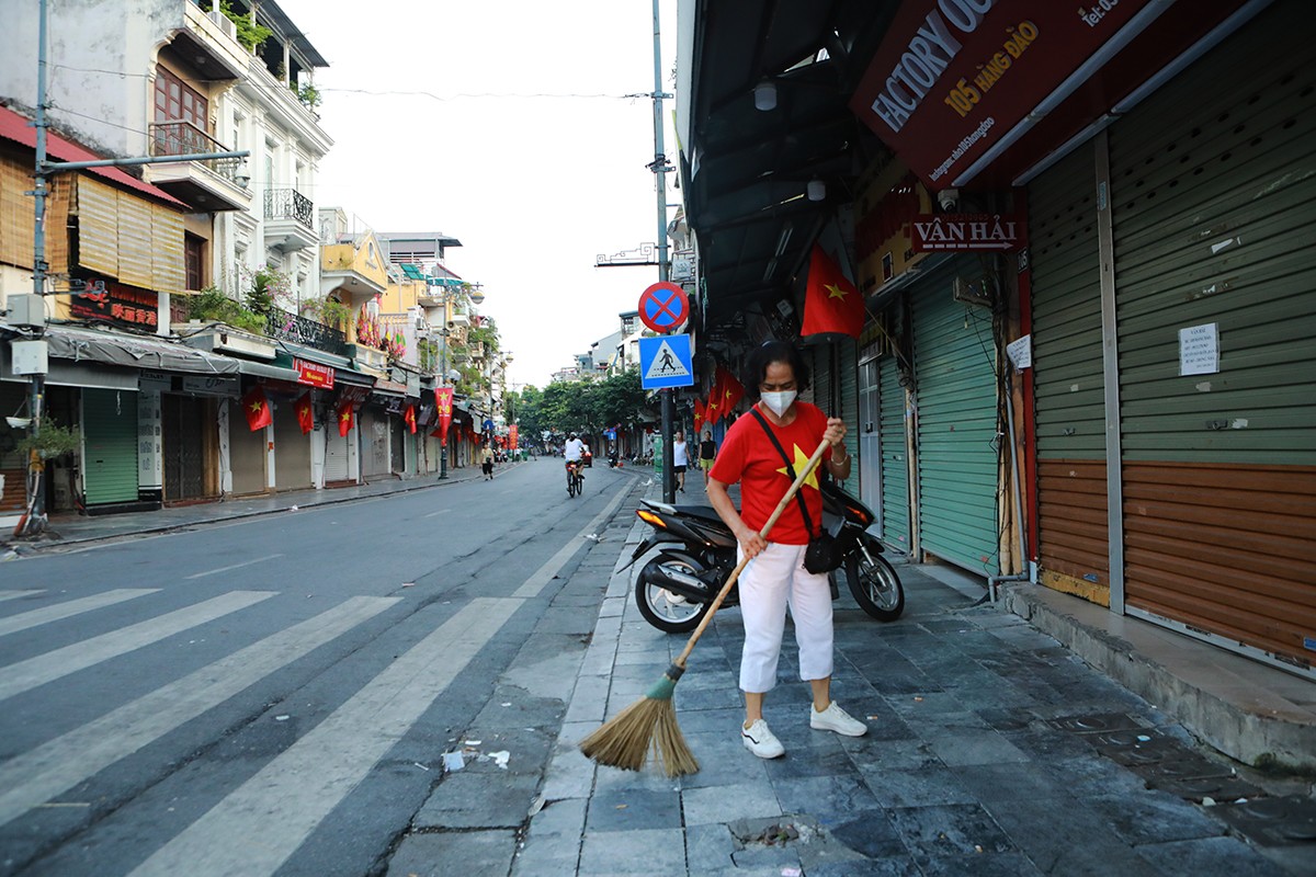 Người dân phố cổ vẫn giữ thói quen dậy thật sớm để làm những công việc hằng ngày, nhưng sáng nay (2/9), một số người mặc áo cờ Tổ quốc làm việc.