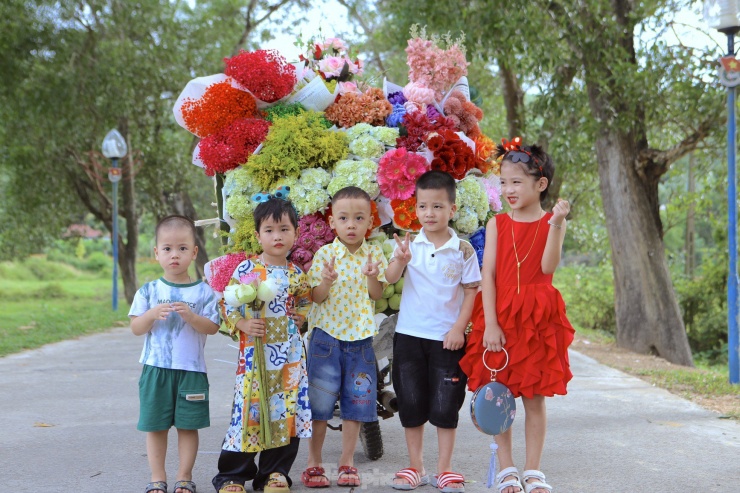 Thời tiết khá mát mẻ cũng là cơ hội cho các em bé được người thân đưa đến con đường có xe chở hoa để chụp hình.