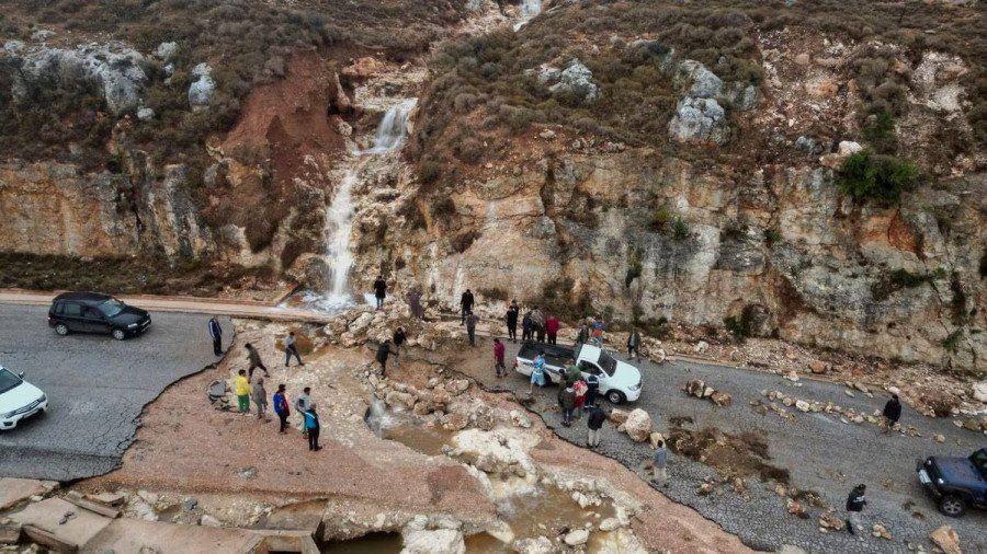 Người dân mắc kẹt trên con đường bị tàn phá nặng nề do mưa bão ở thành phố Shahhat, Libya, ngày 11/9. Ảnh: Reuters