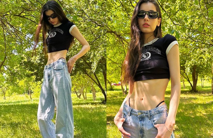 Cô trông cá tính, năng động khi phối áo phông dáng croptop cùng quần jeans giữa vườn cây.
