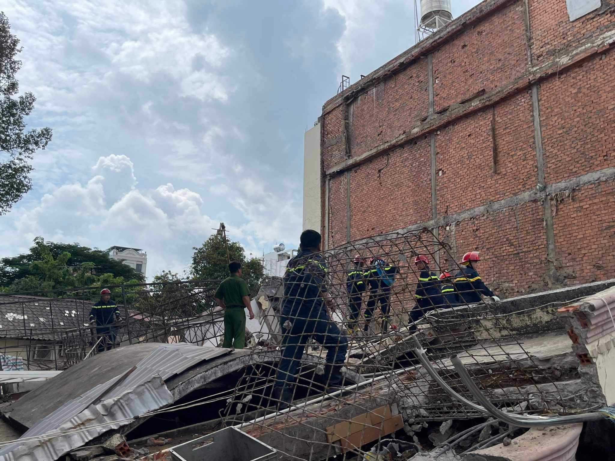 Vụ sập nhà 4 tầng ở TP.HCM: Cảnh sát chui vào các khoảng hở của đống đổ nát để cứu người - 4