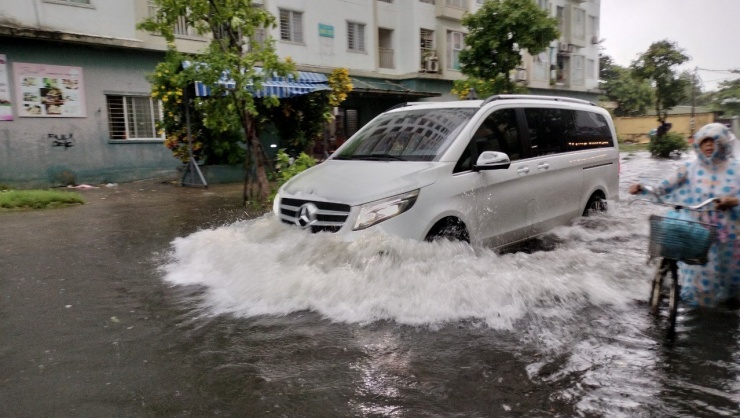 Một tuyến đường nước ngập hơn nửa bánh xe ô tô. Các phương tiện qua lại đều nơm nớp lo ngập nước, chết máy.