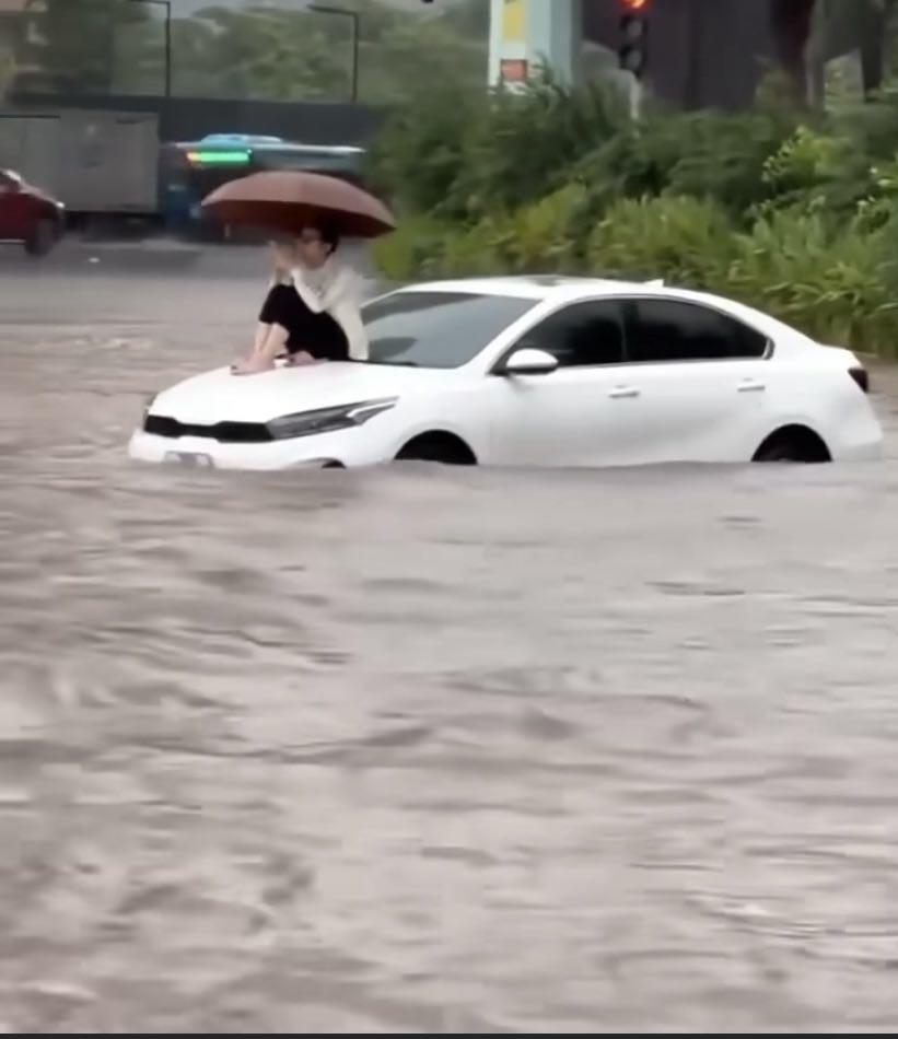 Ung dung ngồi trên nắp capo ô tô bị ngập nước, người phụ nữ lý giải nguyên nhân - 1