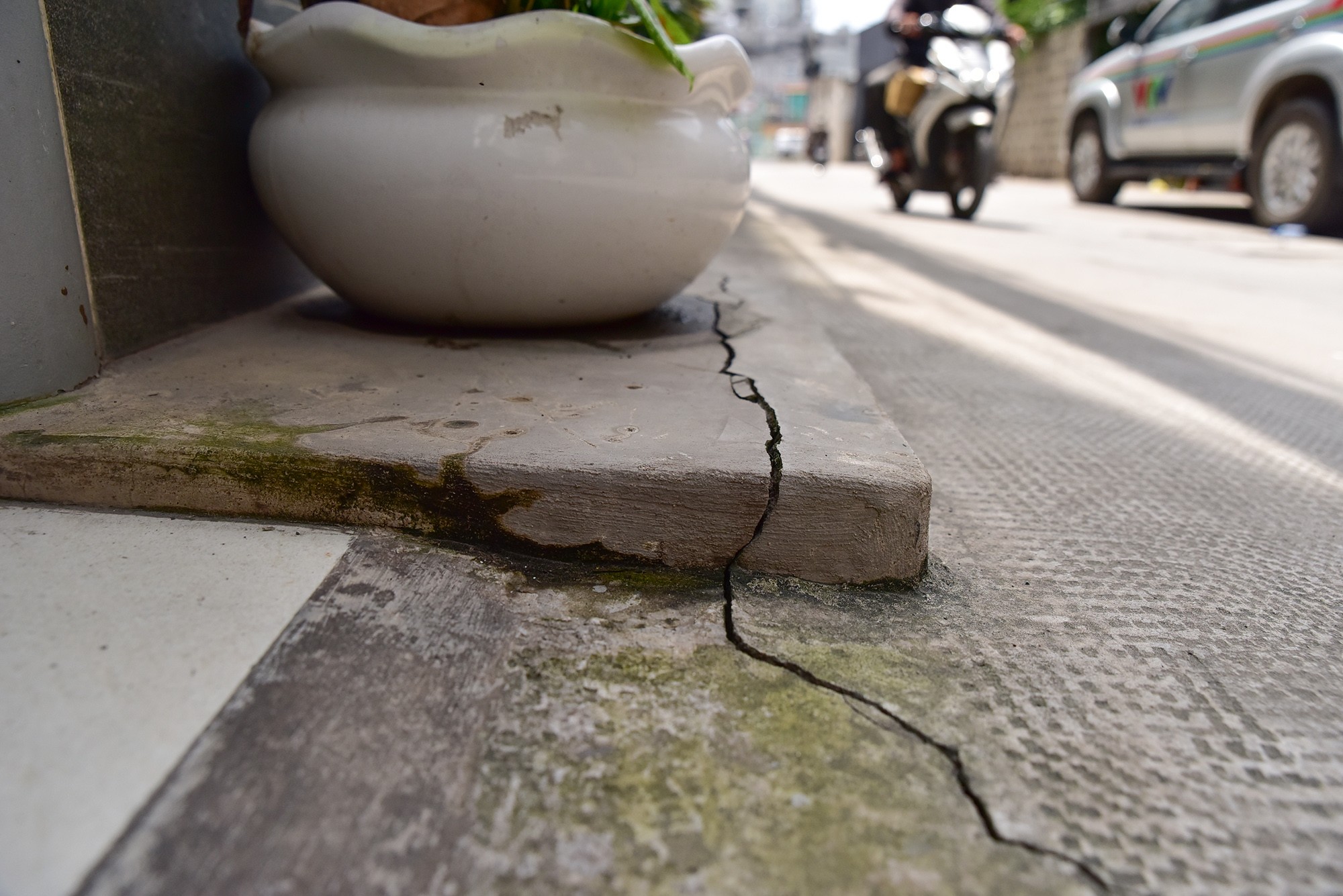 Dọc hai bên đường trước nhiều ngôi nhà xuất hiện những vết nứt kéo dài, một số vị trí bị lún xuống. Khi xe cộ qua lại có thể cảm nhận độ rung của mặt đường phía dưới.