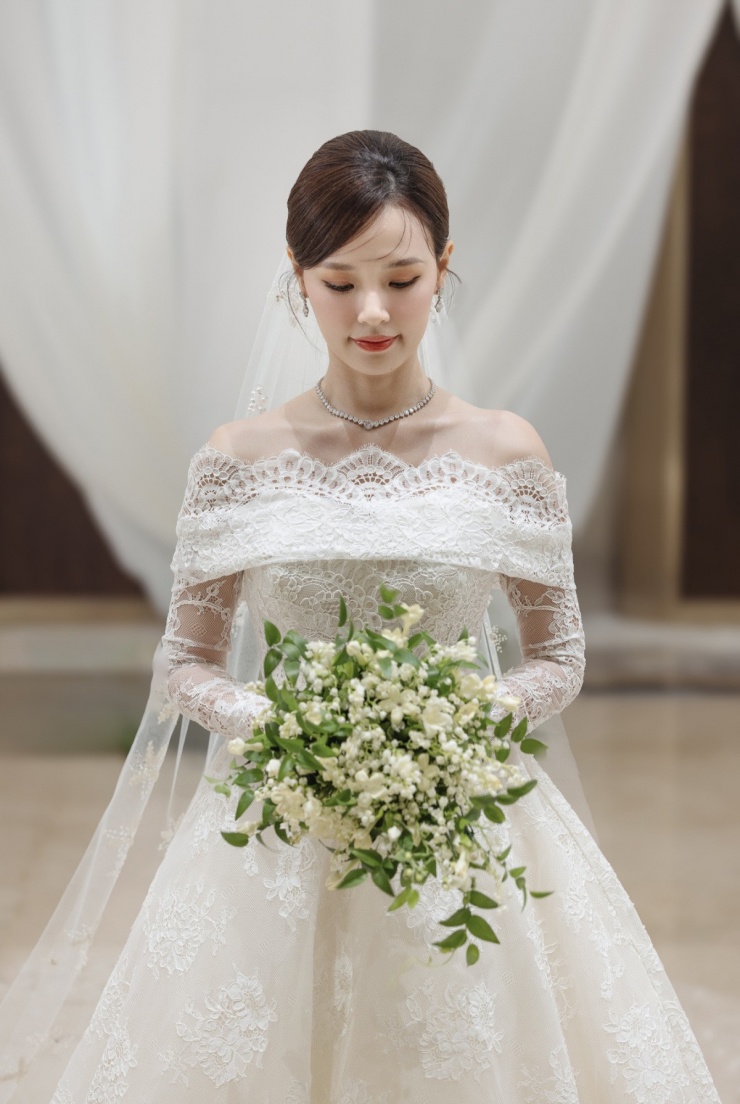 Midu cũng thay đổi trang sức và búi tóc cao khoe vai thon, phù hợp tạo hình cô dâu trong đám cưới hào môn.