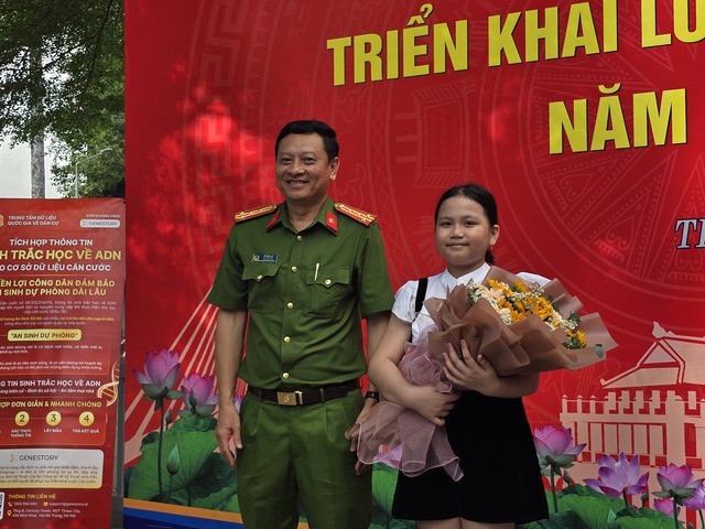 Thượng tá Trần Văn Hải, Trưởng phòng PC06, tặng hoa cho công dân nhí đầu tiên làm căn cước
