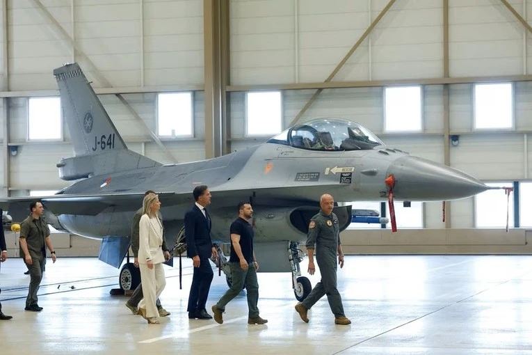 Tổng thống Ukraine - ông Volodymyr Zelensky và Thủ tướng Hà Lan Mark Rutte đi bên cạnh một chiếc máy bay chiến đấu F-16 tại Hà Lan. Ảnh: REUTERS