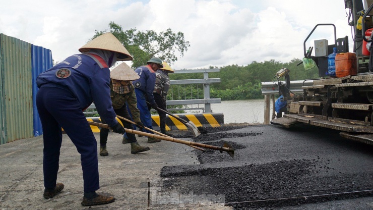 Công nhân gấp rút thảm nhựa khu vực khớp nối cầu Bến Rừng với đường dẫn thuộc địa phận thị xã Quảng Yên (Quảng Ninh).