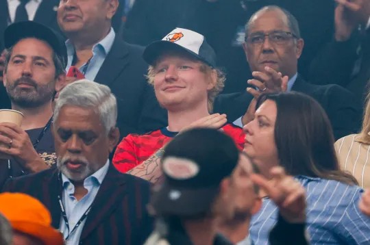 Ed Sheeran nổi bật trên khán đài trong chiếc áo phông đỏ. Ảnh: AFP