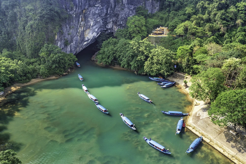 Đội thuyền du lịch nối đuôi nhau chở du khách vào động Phong Nha. Ảnh: B.T