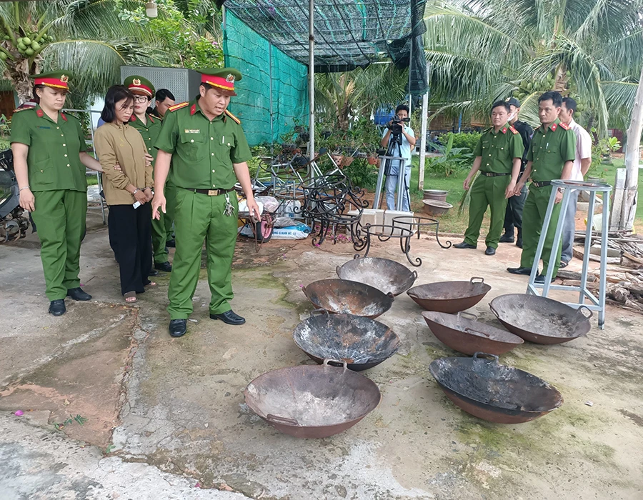 Bắt giam bà Nguyễn Thị Hoài Diễm, bên cạnh là các chảo dùng để đốt lửa hành hình các hình nộm. Ảnh:PHÚ NHUẬN