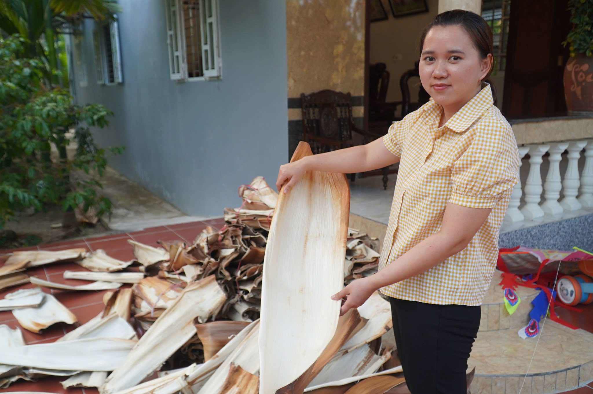 Chị đi thu gom những chiếc mo cau rụng ở vườn về để làm sản phẩm chén, đĩa...