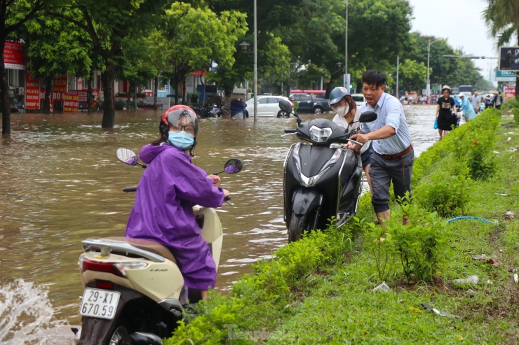 Nhiều phương tiện phải khiêng, dắt trên dải phân cách để tránh bị ngập nước.