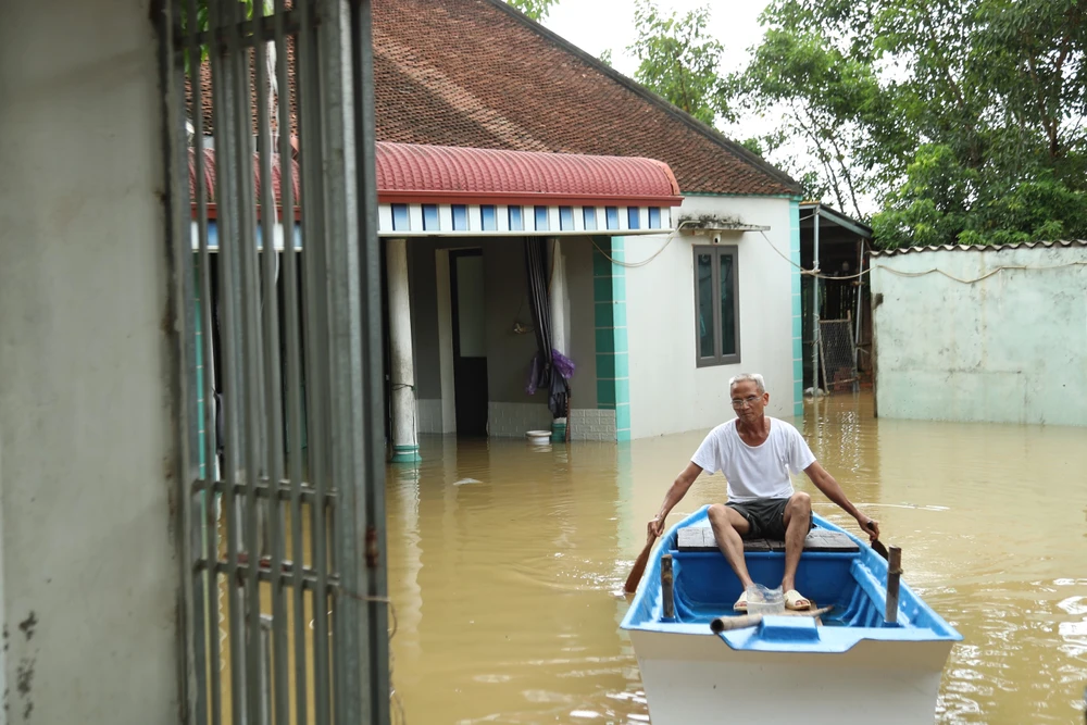 Lũ tràn đê sông Bùi khiến làng xá ven sông bị ngập, giao thông chia cắt, người dân phải di chuyển bằng thuyền. Ảnh: TP