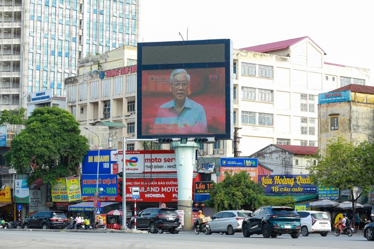 Ngã tư đường Cầu Giấy (quận Cầu Giấy) là khu vực trung tâm, nhiều người đi bộ, dừng đèn đỏ dễ dàng xem được thông tin trong bộ phim tài liệu về Tổng Bí thư