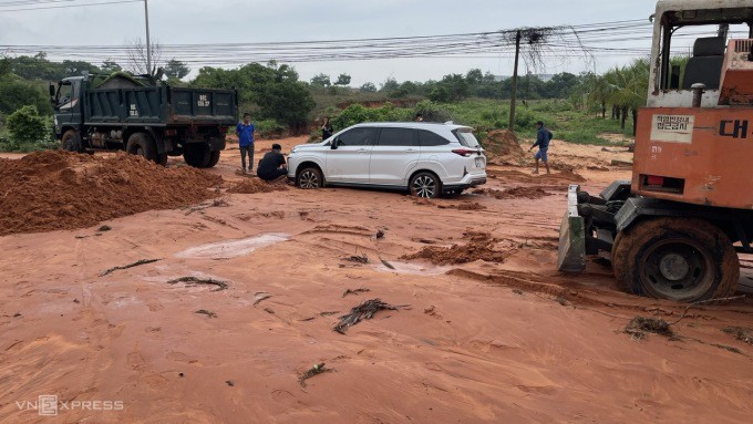 Một ôtô đi qua đường Phú Hài bị mắc kẹt trong bùn cát đỏ, sáng 27/7. Ảnh: Việt Quốc