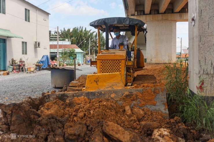 Bên dưới cầu nhiều công nhân, máy móc tất bật thi công các đường dân sinh. Thời gian tới, công trình sẽ được thảm nhựa đường dẫn, lắp biển báo, hệ thống chiếu sáng...