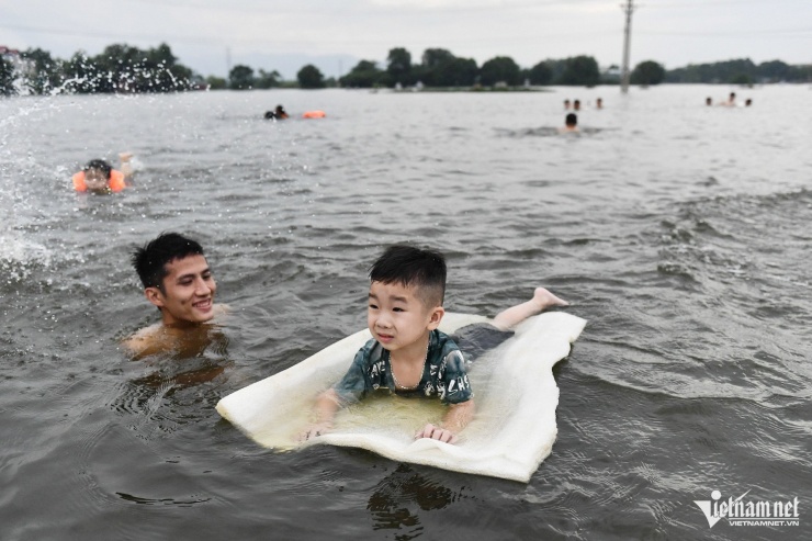 Bé Công Phúc được người lớn đưa ra đây tập bơi với miếng xốp đủ để đỡ trọng lượng cơ thể. 