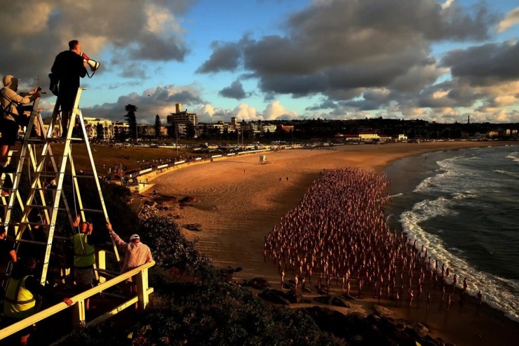 Spencer Tunick hướng dẫn một đám đông tình nguyện viên sắp xếp cho buổi trình diễn và chụp ảnh khoả thân trên bãi biển Sydney. Ảnh: Don Arnold/WireImage.