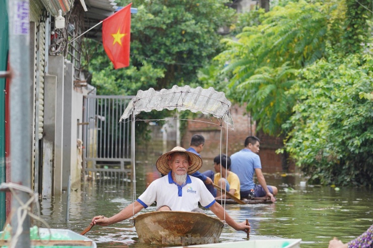 Ông Nguyễn Huy Tắc (thôn Nhân Lý) chèo thuyền từ sâu trong làng ra ngoài để nhận hỗ trợ. Ông Tắc cho biết, mấy hôm trước nhà ông ngập gần 2 mét, không thể ở, phải đến ở nhờ nhà người quen ở trên cao. 