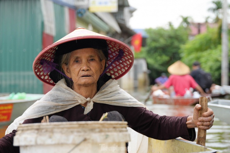 Cụ Lực (82 tuổi) vẫn chèo thuyền để ra ngoài làng để nhận lương thực, thực phẩm và nước mang về sinh hoạt.