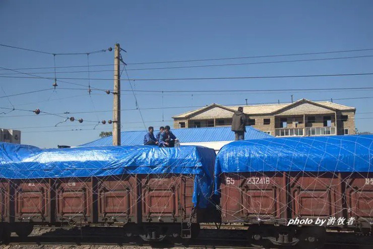 Nhân viên đang ngồi trò chuyện trên nóc một đoàn tàu chở hàng tại Triều Tiên (Ảnh: Người Du Mục)