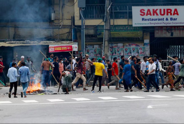 Một nhóm cầm gậy gộc trong cuộc biểu tình ngày 4/8 để đòi Thủ tướng Bangladesh Sheikh Hasina từ chức. (Ảnh: Reuters)