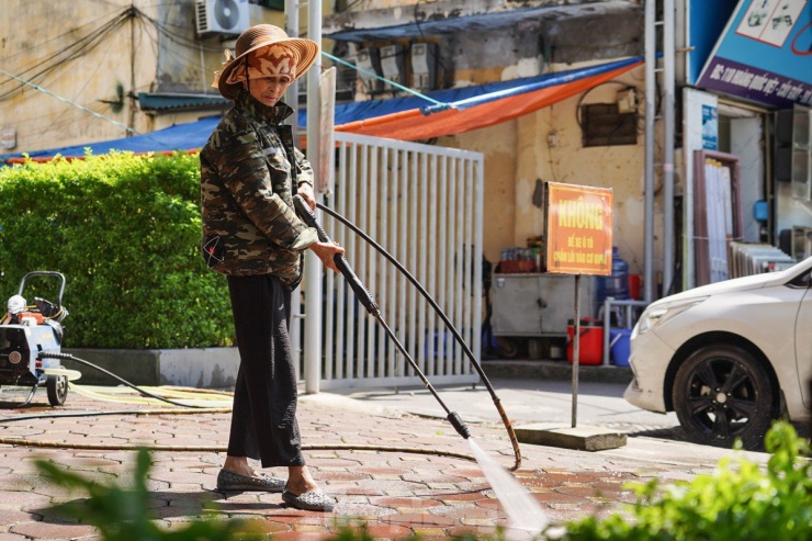 Vào thời điểm khoảng 11h, dưới cái nắng như đổ lửa của Hà Nội, bà Liên (lao công tại một tòa nhà ở Cầu Giấy) vẫn miệt mài dùng vòi nước để rửa vỉa hè. Bà chia sẻ: 