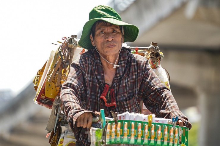 Một người đàn ông bán hàng rong, trên ngực áo luôn sẵn một chiếc khăn để lau những giọt mồ hôi lăn dài trên mặt trong lúc thời tiết nắng nóng.